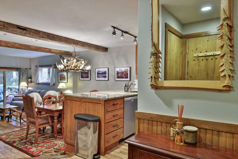 Walk in beside the kitchen and the dining table, fireplace, and patio unfold ahead.