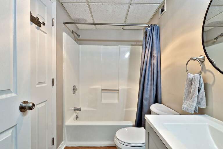 The bathroom has a combined tub and wall-mounted shower beside the sink.