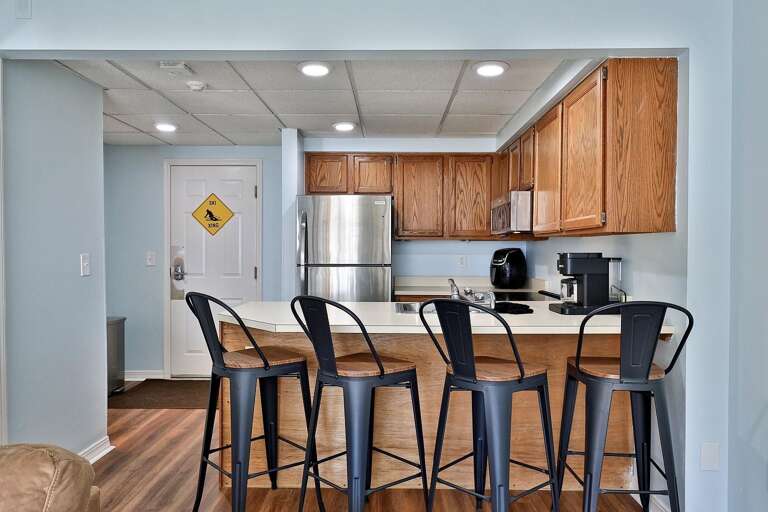 Four counter stools face the kitchen for quick meals and conversation.