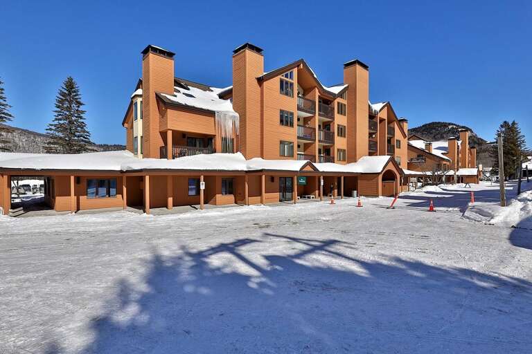 The lodge exterior has a covered arrival area beside the main entrance.