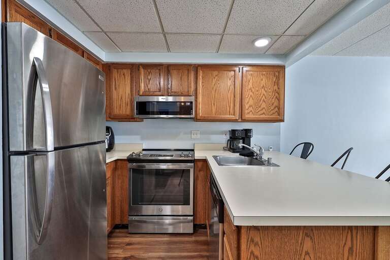 The refrigerator and range sit behind the breakfast bar in the open kitchen.