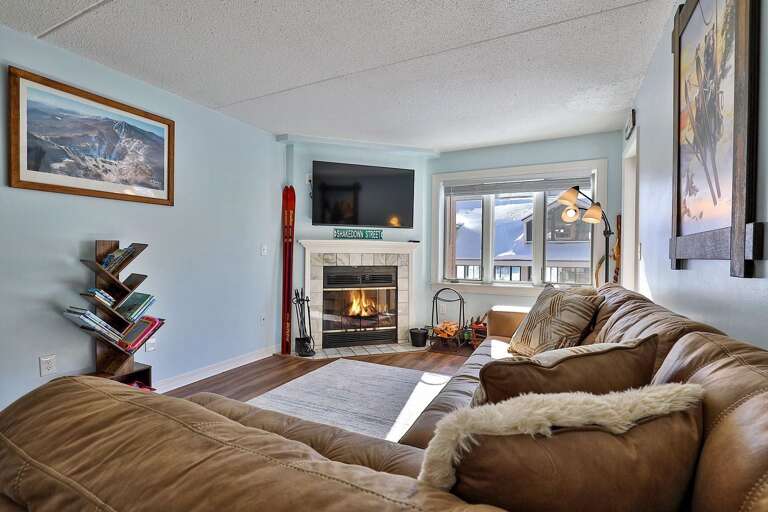 The sectional and fireplace share an open space with the breakfast bar just behind.