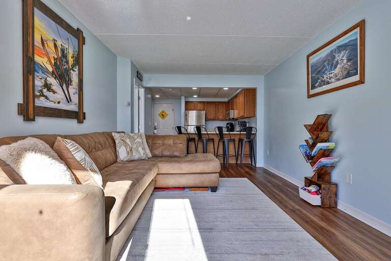 The sectional stretches along the open room, with the kitchen and breakfast bar at the far end.