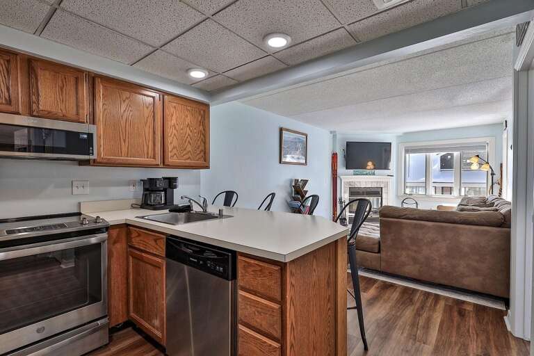 The sink and dishwasher face the living room across the breakfast bar.