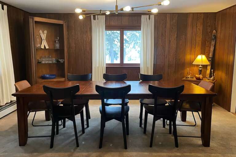 The dining table seats 10, with another five seats at the kitchen island nearby.