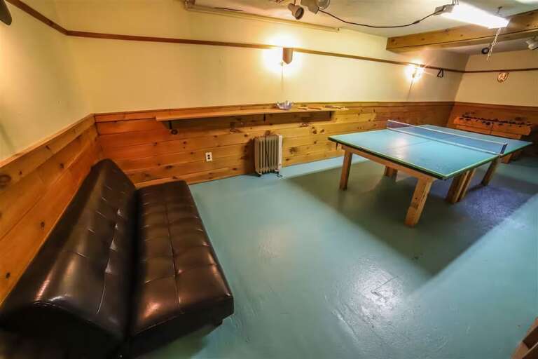 Challenge someone to a game of ping-pong in the basement, with a sofa beside the table.