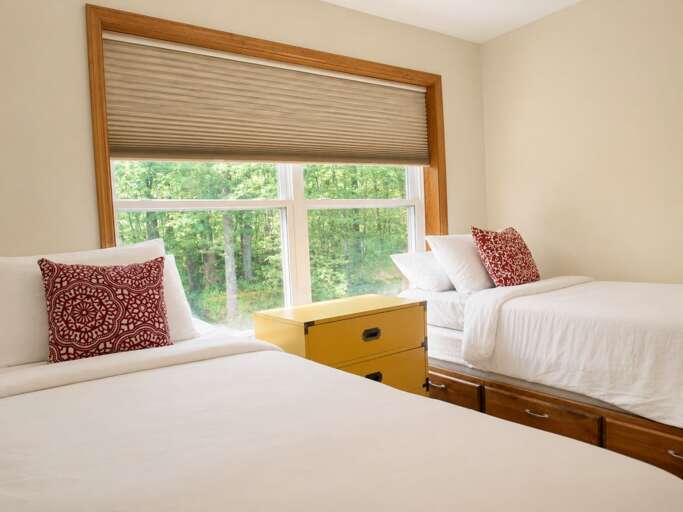 Share a bedroom without sharing a bed; this room has two twins beside a large window.