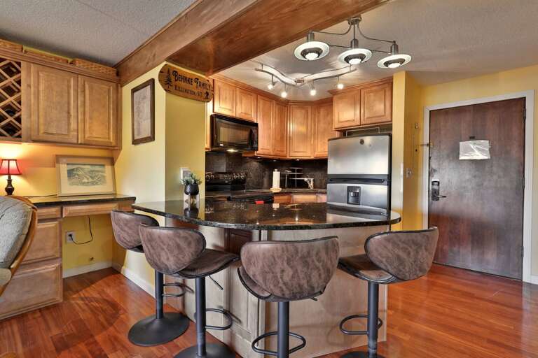 Three stools line the kitchen counter for coffee, breakfast or a quick lunch.