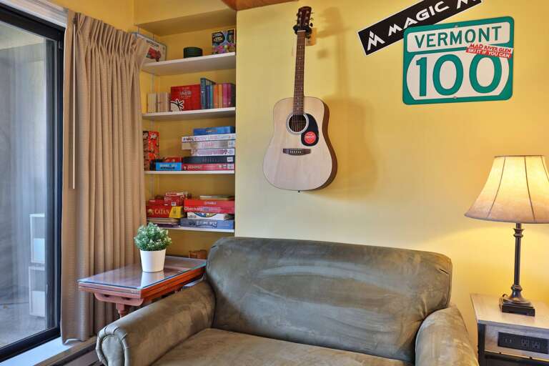 The shelves beside the armchair hold books and board games for an evening indoors.