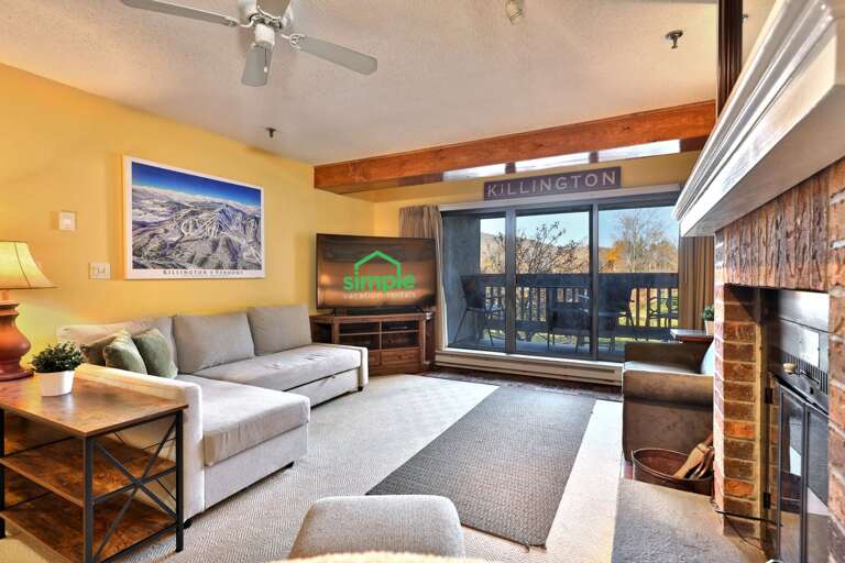 Settle onto the sectional with the TV nearby and balcony doors across the room.