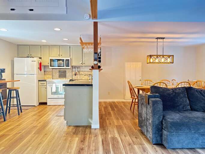 Upstairs, the kitchen opens to the dining and living areas, with the bedrooms downstairs on the entry level.