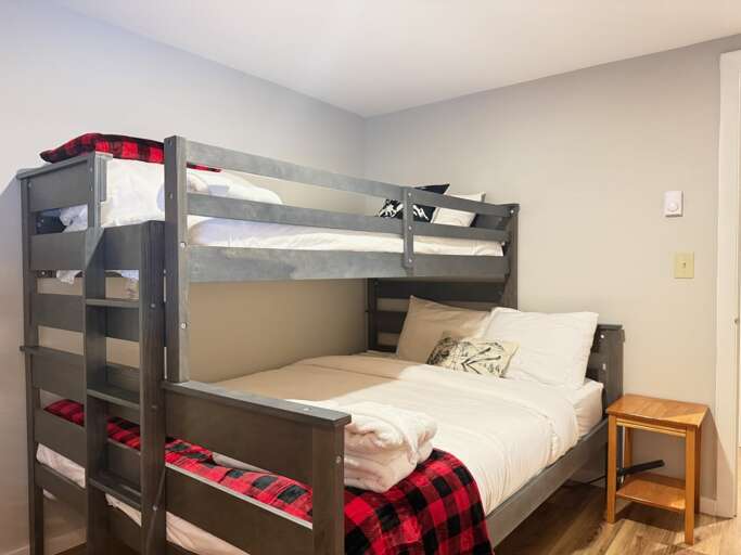The queen lower bunk has open access at the foot, while a ladder leads to the twin above.