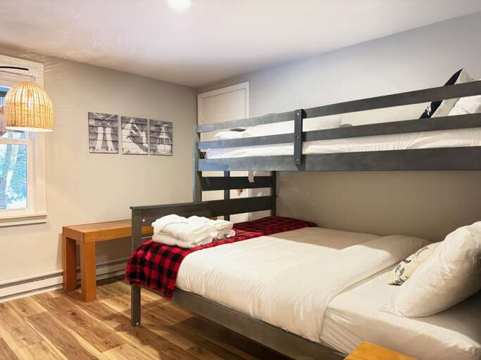 The third bedroom pairs a queen lower bunk with a twin above, on the entry level with the other bedrooms.