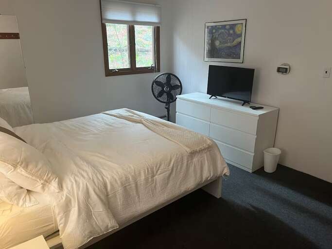 Watch from bed in bedroom two, which also has a dresser for clothes.