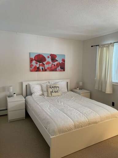 Bedroom four has one queen bed and bedside tables for lamps and personal items.