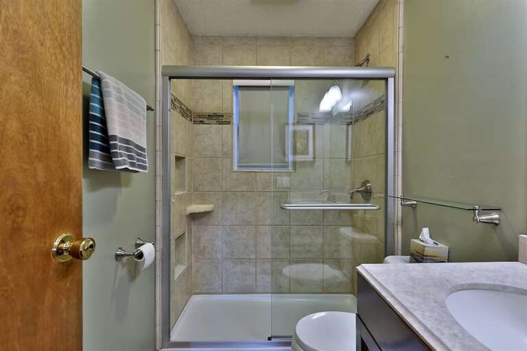 One full bathroom has a tiled shower with sliding glass doors.