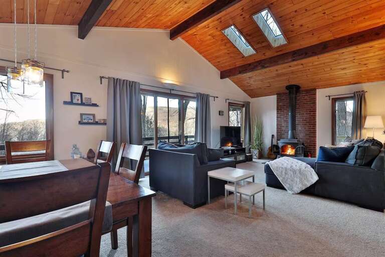 Dinner and the living area share one open space beneath timber ceilings and skylights.