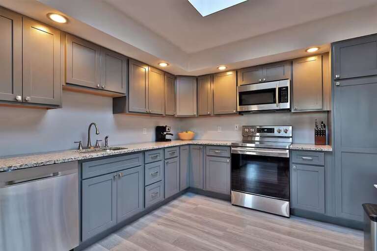 An electric range, oven, microwave, and dishwasher cover the cooking and cleanup.