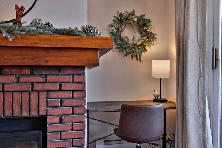 Set up a laptop or open your journal at the small desk next to the fireplace.