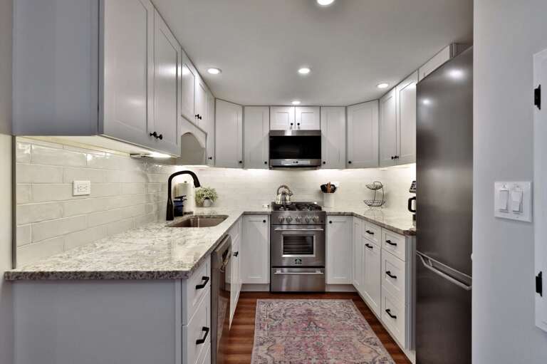 Prepare dinner in the galley kitchen, with counters on both sides and the range at the far end.