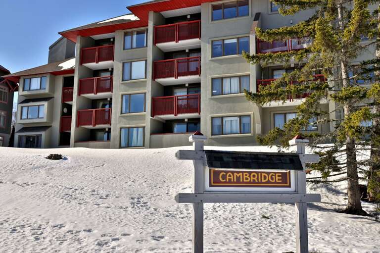 The Cambridge sign stands in front of the building and its red balconies.