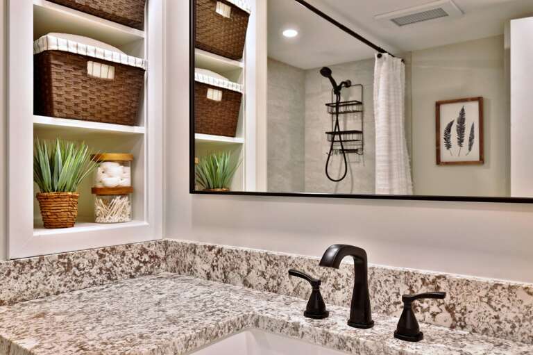 Shelving and baskets sit next to the vanity for organizing small bathroom items.