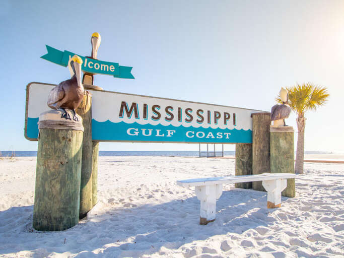 Welcome Sign For Mississippi Gulf Coast On A Sunny Beach Welcome Sign For Mississippi Gulf Coast On A Sunny Beach