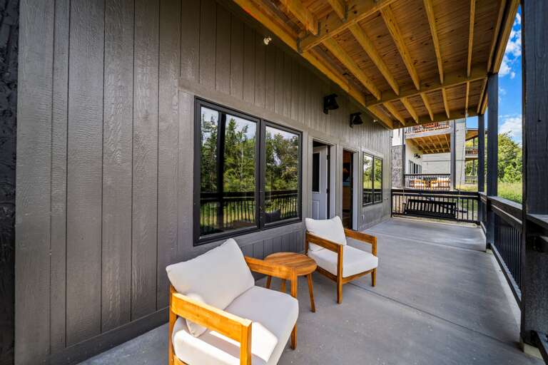 Relax on the lower-level terrace with a swing and seating area by the pool and game room.
