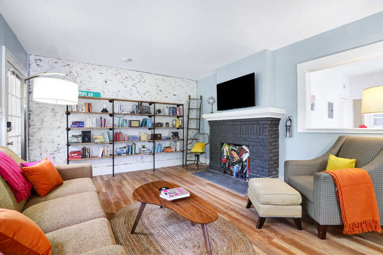 Modern Living Room With Sofa, Armchair, Fireplace, And Bookshelf