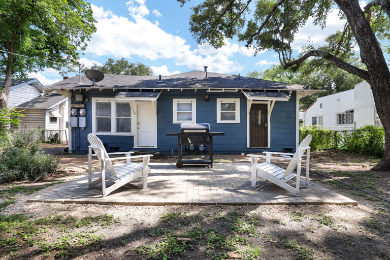 Blue House With White Chairs Outside