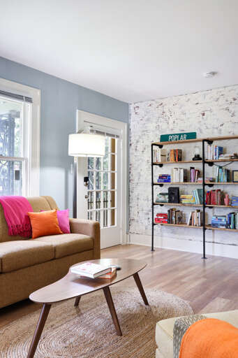 Living Room With Sofa, Coffee Table, Bookshelf, And French Doors