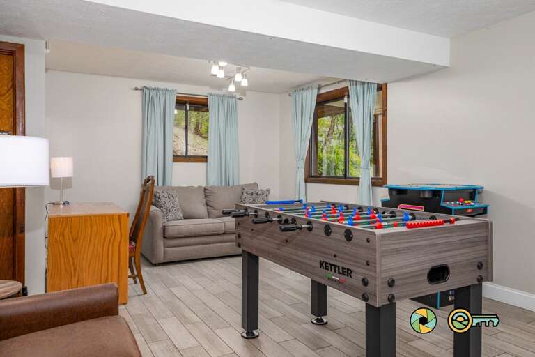 Living Area With Foosball Table, Sofa, And Side-view Of Kitchen