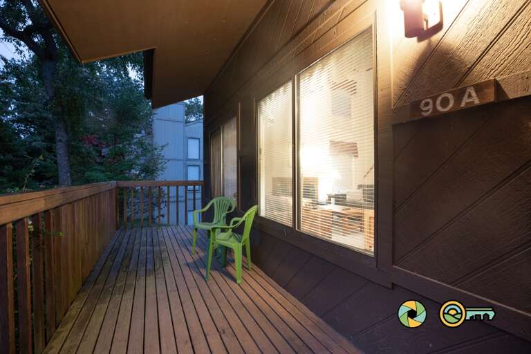 Wooden Balcony With A Green Chair At Dusk