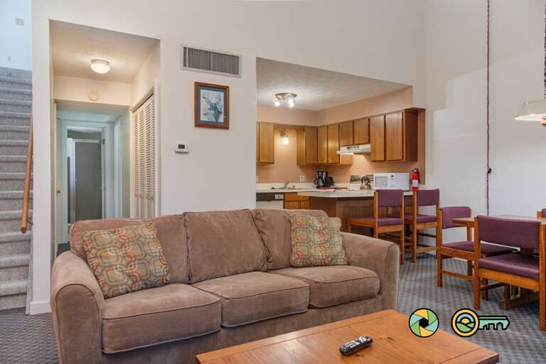 Living Room With Sofa, Kitchen Area, And Dining Table