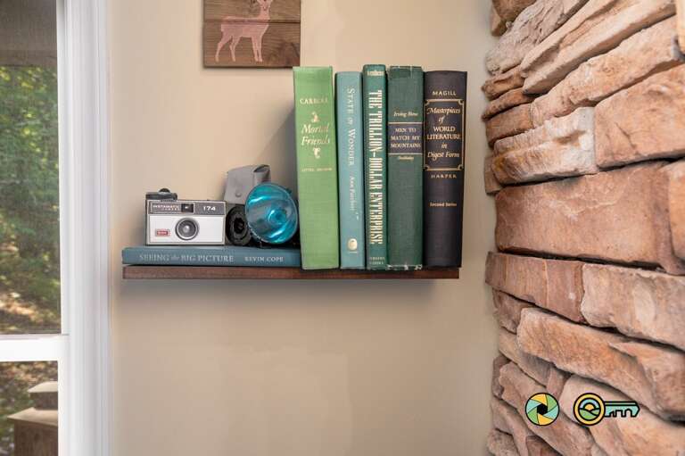 Books And Camera On A Shelf Beside A Brick Wall Books And Camera On A Shelf Beside A Brick Wall