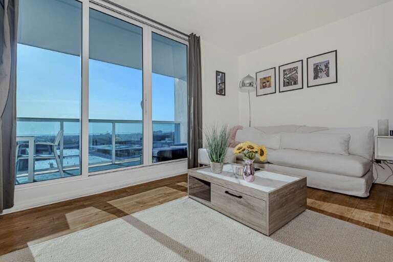Modern Living Room With Sofa And Large Window Overlooking A City Modern Living Room With Sofa And Large Window Overlooking A City