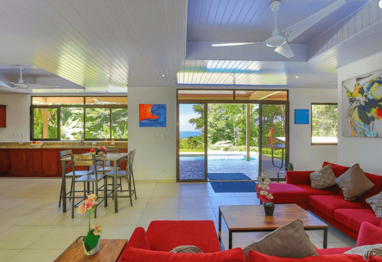 Modern Living Room With Red Sofas And Ocean View Through Large Windows
