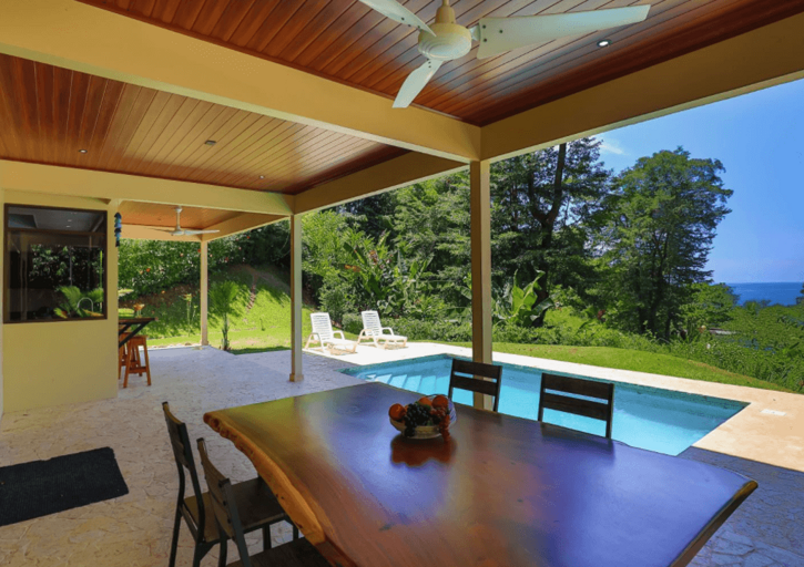 Outdoor Patio With Dining Table Overlooking Pool And Ocean