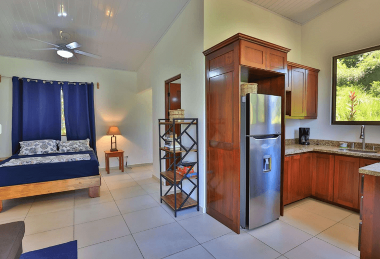 Interior Of A Room With Bed, Kitchenette, And Fridge