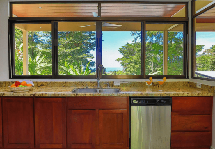Kitchen Interior With Wooden Cabinets And Large Window Overlooking Trees