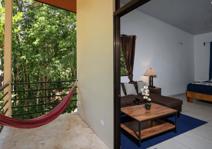 Room Interior With Open Sliding Door To Balcony And Hammock