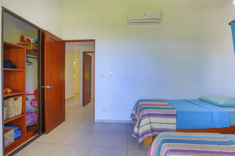 Interior Of A Simple Bedroom With Two Beds And A Wardrobe