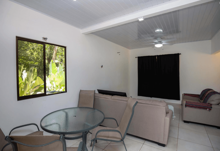 Interior Of A Living Room With Furniture And A View Of Greenery Outside