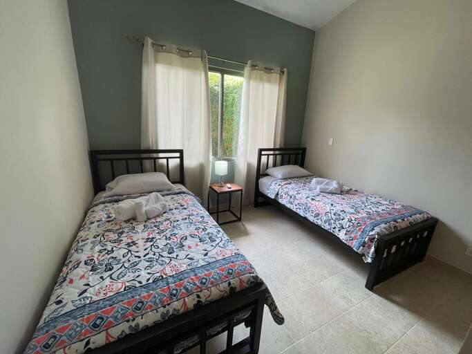 Twin Beds In A Simple Room With Curtains And A Nightstand Twin Beds In A Simple Room With Curtains And A Nightstand