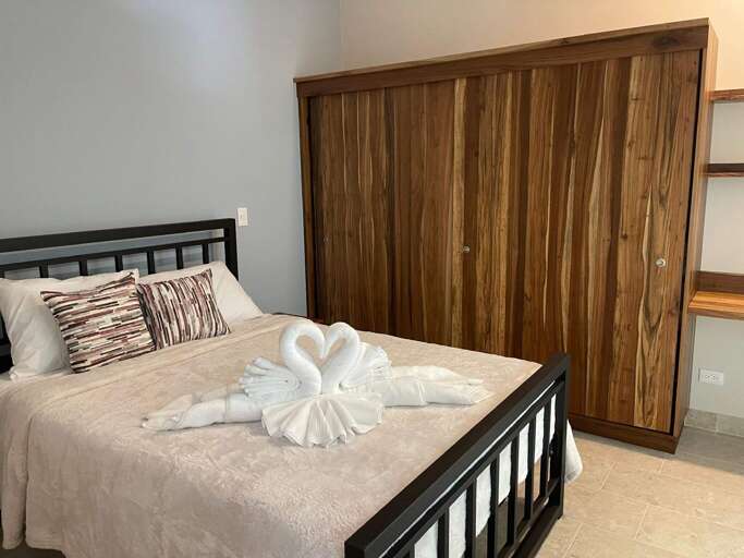 Bedroom With Bed, Decorative Towel, And Wooden Closet Bedroom With Bed, Decorative Towel, And Wooden Closet