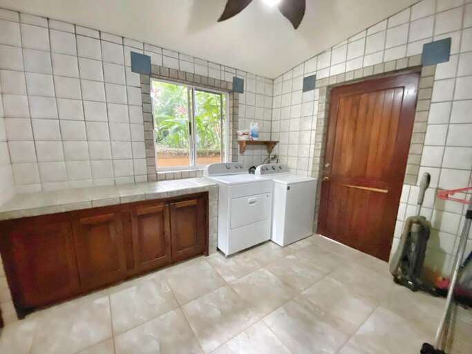 Kitchen Interior With Cabinets, Sink, Washing Machine, And A Door