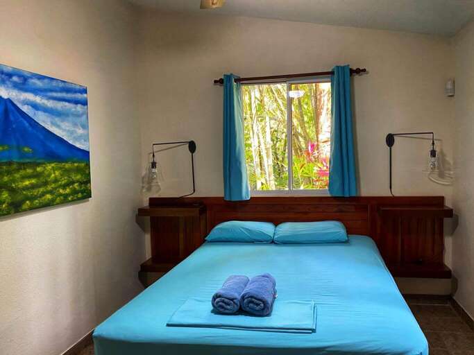Bedroom With Blue Bedding, Window, And Wall Art