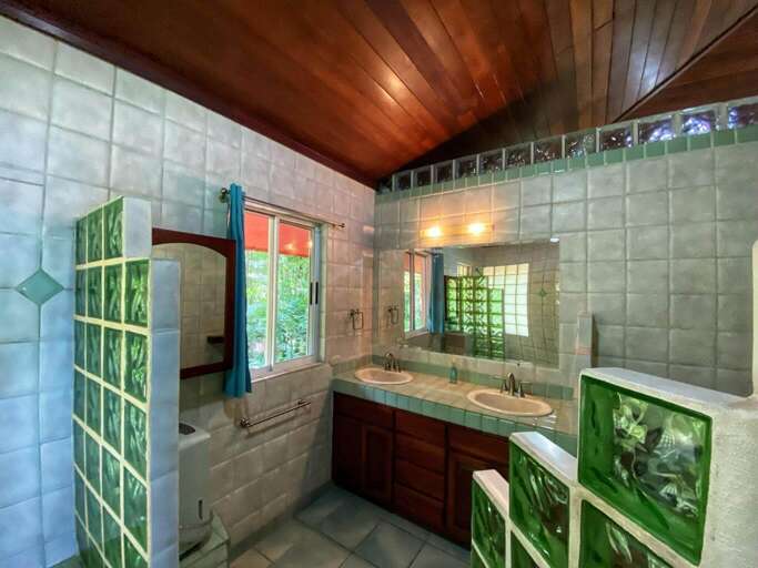 Interior View Of A Bathroom With Wooden Ceiling And Tiled Walls