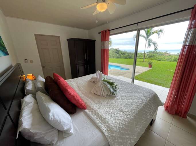 Bedroom With Bed, Ceiling Fan, And View Of Pool And Lawn Bedroom With Bed, Ceiling Fan, And View Of Pool And Lawn