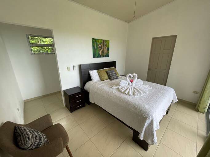 Interior Of A Simple Bedroom With A Decorated Bed And A Chair Interior Of A Simple Bedroom With A Decorated Bed And A Chair